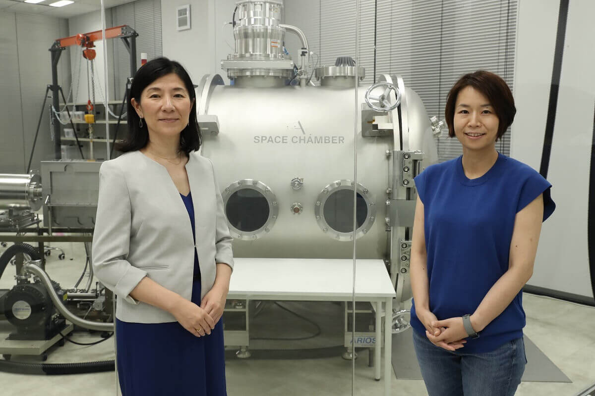 真空チャンバーの前に立つALE 岡島礼奈 様(右)と当社 則長
